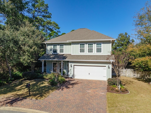 view of property featuring a garage and a front lawn