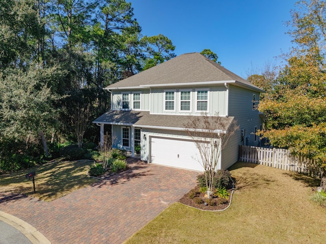 view of property featuring a garage and a front yard