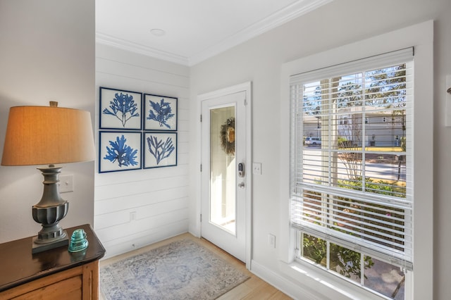 entryway with wood-type flooring, wood walls, and crown molding