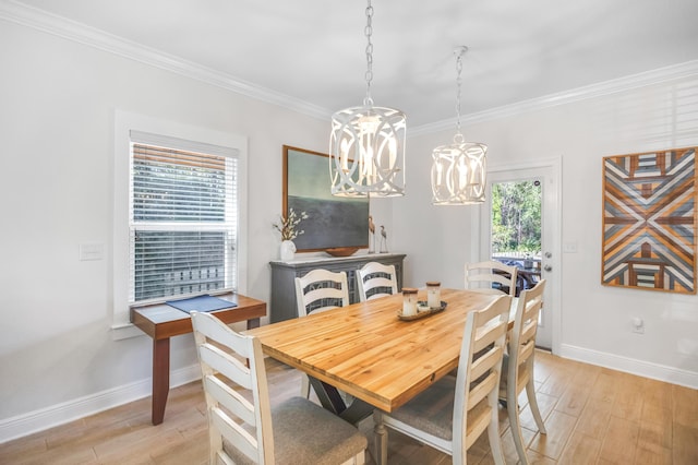 dining area featuring light wood-type flooring, a chandelier, and ornamental molding