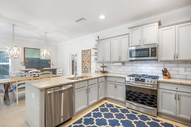 kitchen featuring backsplash, pendant lighting, appliances with stainless steel finishes, and kitchen peninsula