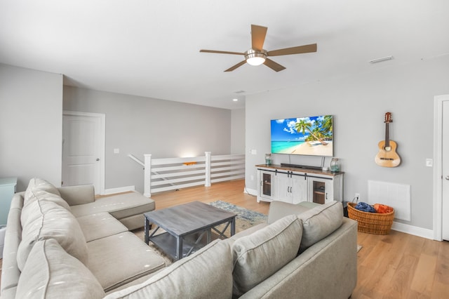 living room featuring light hardwood / wood-style flooring, wine cooler, and ceiling fan