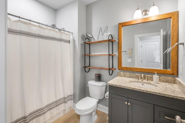 bathroom with curtained shower, toilet, and vanity