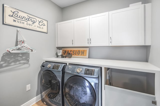 washroom with cabinets, hardwood / wood-style flooring, and washer and clothes dryer