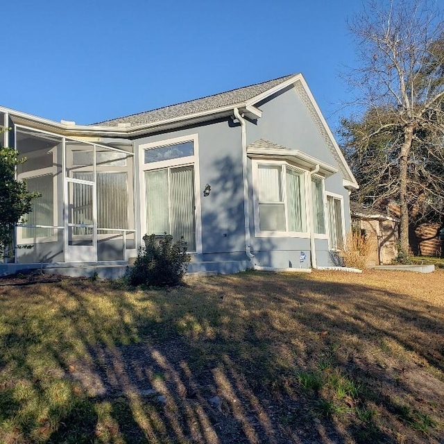 view of side of property with a yard and a sunroom