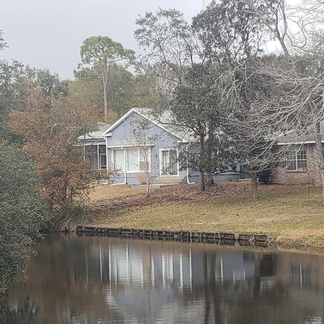 exterior space with a water view and a lawn