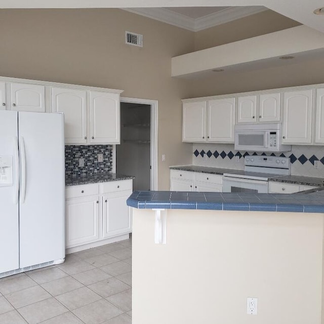 kitchen featuring light tile patterned floors, white appliances, ornamental molding, white cabinets, and tile countertops