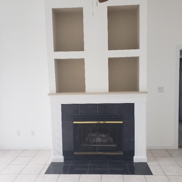 interior details featuring ceiling fan and a tiled fireplace