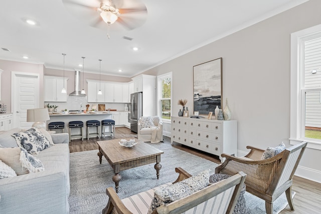 living room featuring sink, ceiling fan, ornamental molding, and wood-type flooring