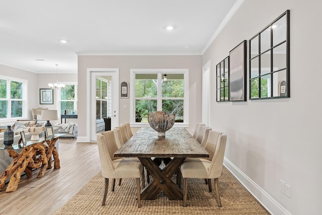 dining area featuring crown molding, a notable chandelier, and light wood-type flooring