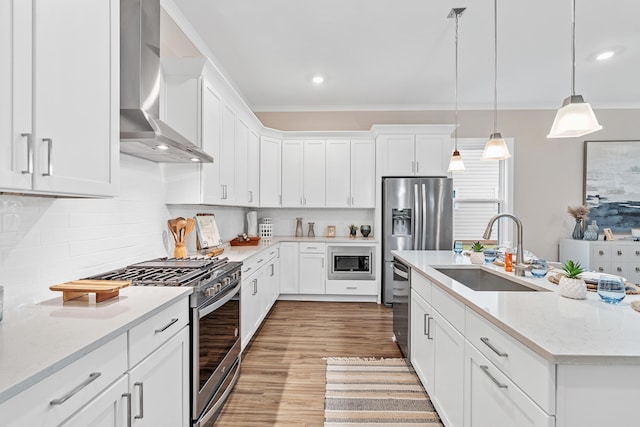 kitchen featuring wall chimney exhaust hood, sink, white cabinetry, and stainless steel appliances