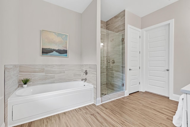 bathroom featuring hardwood / wood-style floors, vanity, and shower with separate bathtub