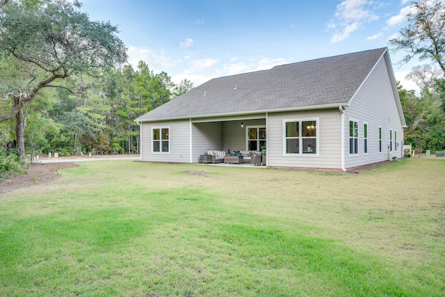 back of house with a yard and an outdoor living space