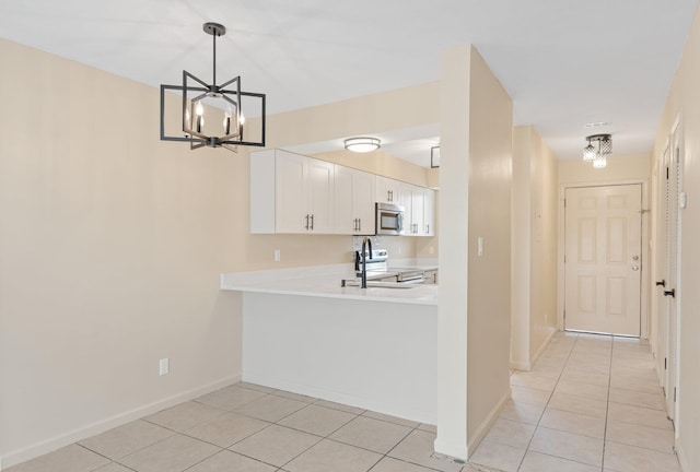 kitchen with light tile patterned flooring, white cabinetry, hanging light fixtures, a notable chandelier, and stainless steel appliances