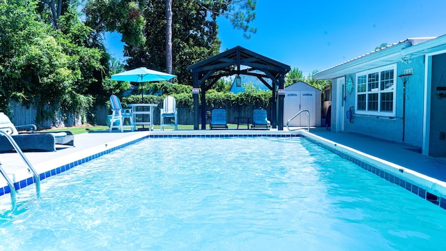 view of swimming pool with a gazebo and a storage shed