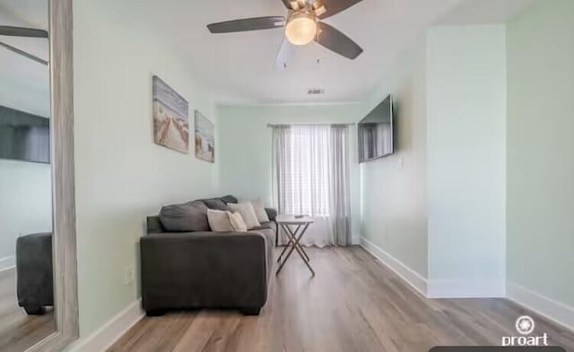 living area featuring light wood-type flooring and ceiling fan