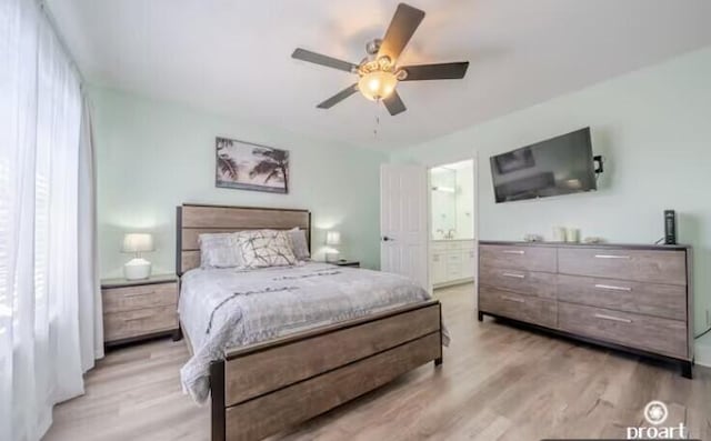 bedroom with light wood-type flooring, ensuite bathroom, and ceiling fan