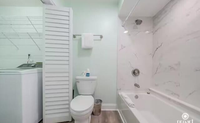 bathroom featuring wood-type flooring, bathtub / shower combination, toilet, and washer / clothes dryer