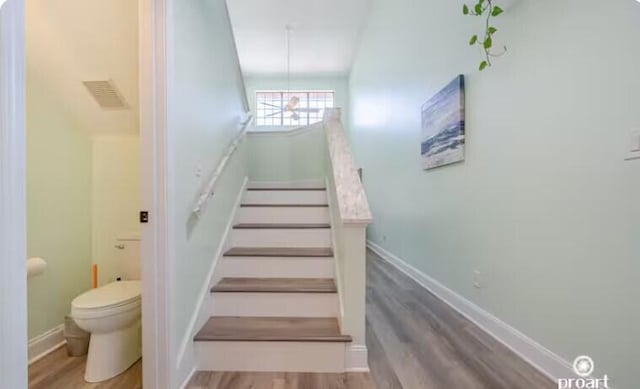 stairs featuring hardwood / wood-style floors