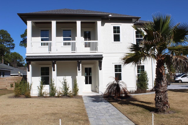 view of front of home featuring a balcony and a front yard