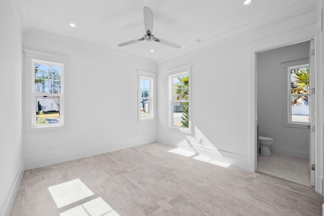 unfurnished bedroom with crown molding, ensuite bath, ceiling fan, and multiple windows