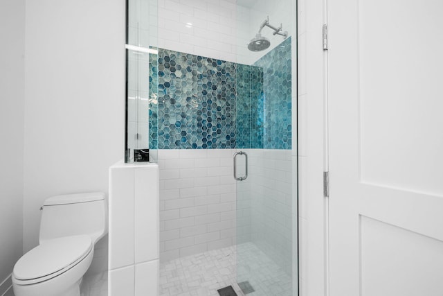 bathroom with a shower with door and toilet