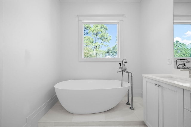 bathroom featuring vanity, a wealth of natural light, tile patterned floors, and a tub to relax in