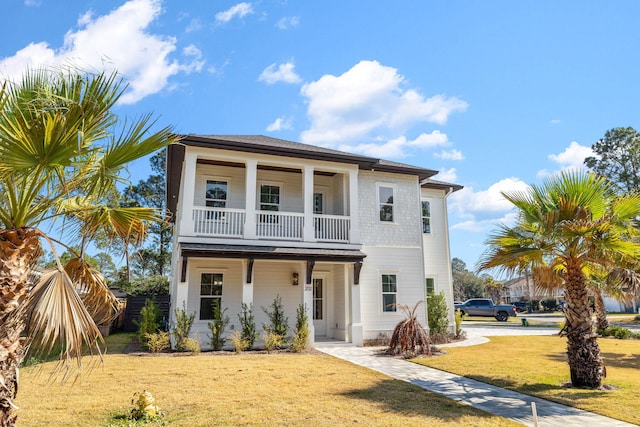 view of front of house with a balcony and a front lawn