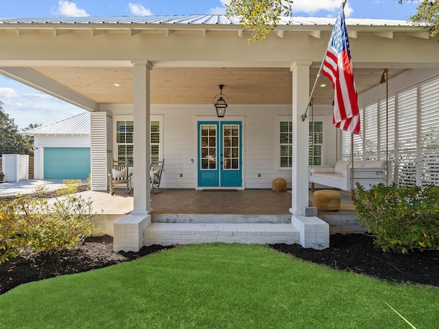 doorway to property with a garage and covered porch