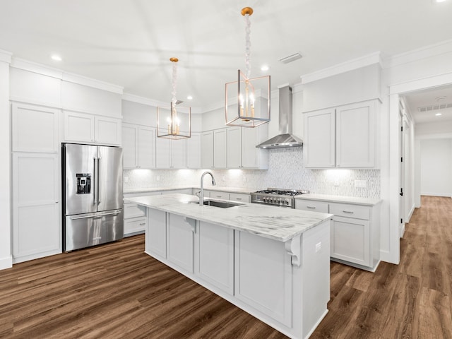 kitchen with sink, appliances with stainless steel finishes, white cabinetry, a center island with sink, and wall chimney exhaust hood