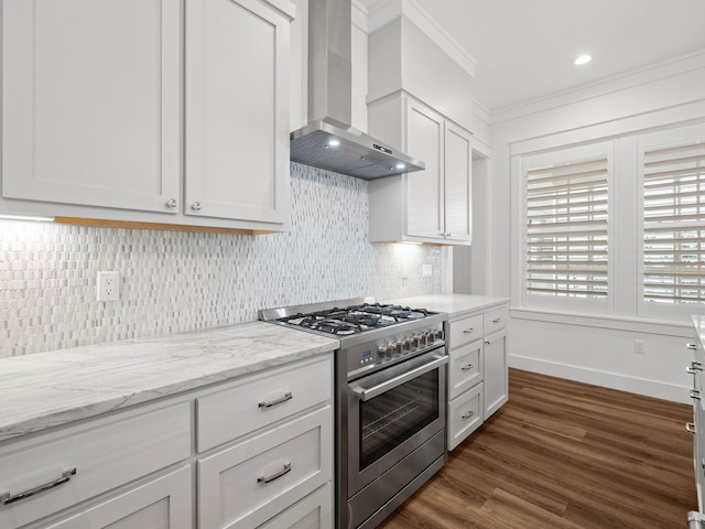 kitchen with high end range, white cabinetry, dark wood-type flooring, and wall chimney exhaust hood