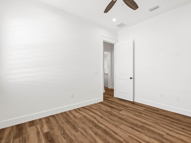 spare room featuring dark wood-type flooring and ceiling fan