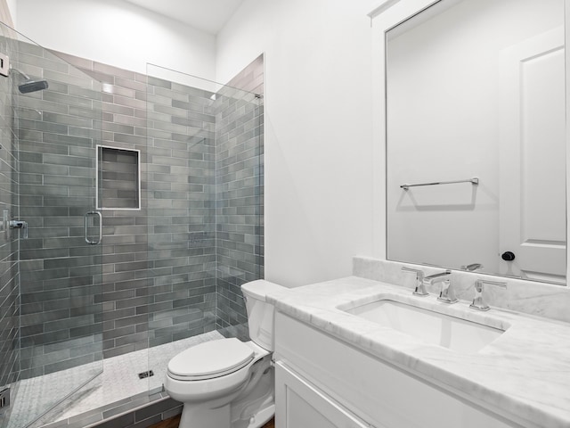 bathroom with vanity, a shower with shower door, and toilet