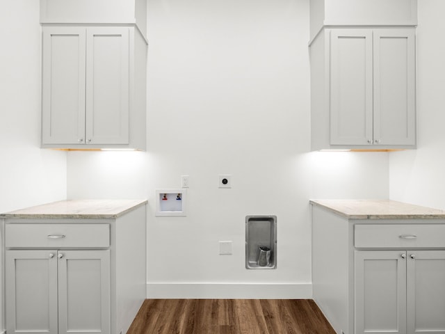 clothes washing area featuring electric dryer hookup, hookup for a washing machine, dark hardwood / wood-style flooring, and cabinets