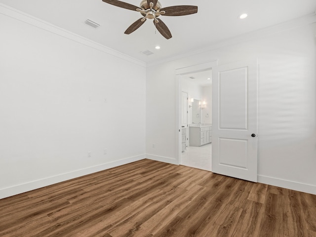 empty room featuring crown molding, wood-type flooring, and ceiling fan