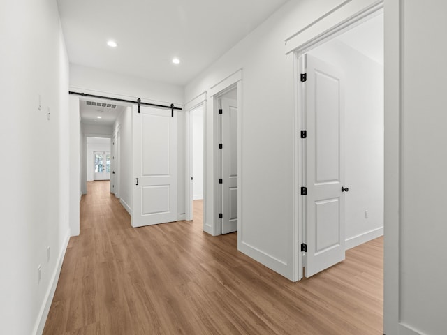 hall featuring light hardwood / wood-style flooring and a barn door