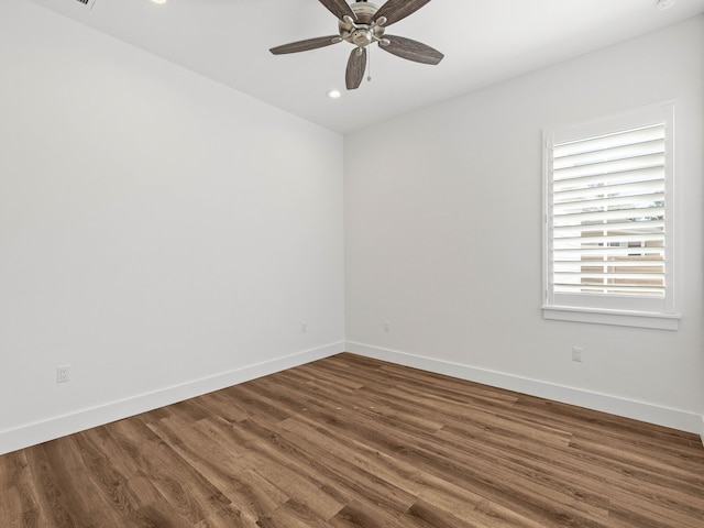 empty room featuring dark wood-type flooring and ceiling fan