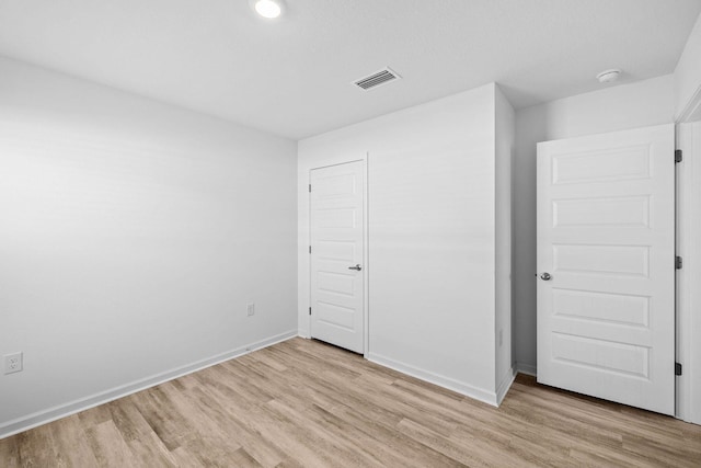 unfurnished bedroom featuring light hardwood / wood-style flooring and a closet