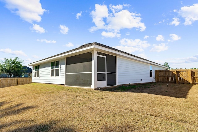 back of property featuring a lawn and a sunroom