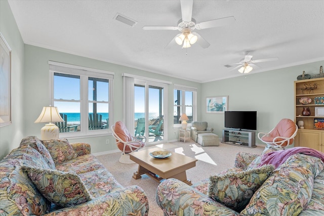 carpeted living room with ceiling fan, crown molding, a textured ceiling, and a water view