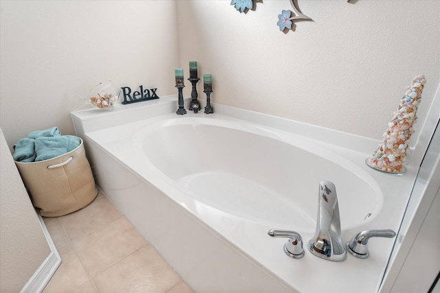 bathroom with tile patterned floors and a bath