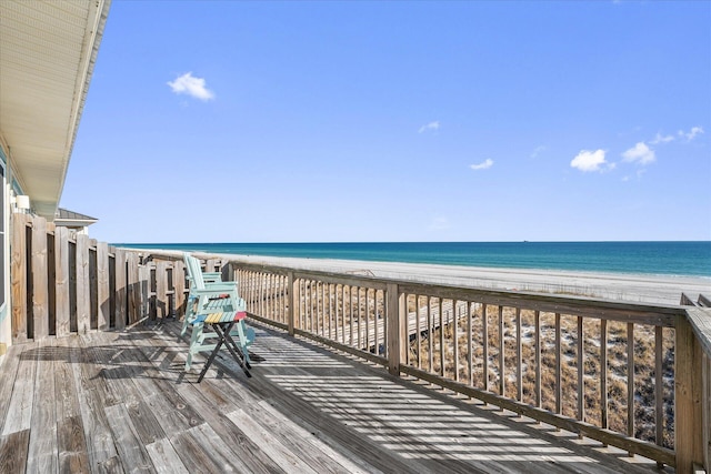 wooden terrace with a water view and a view of the beach