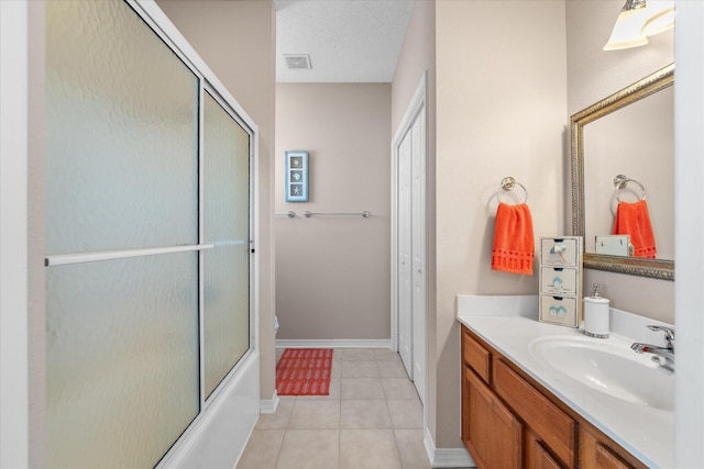 bathroom with vanity, tile patterned flooring, a textured ceiling, and combined bath / shower with glass door