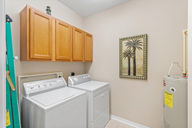 laundry area featuring cabinets, a textured ceiling, water heater, and washing machine and clothes dryer