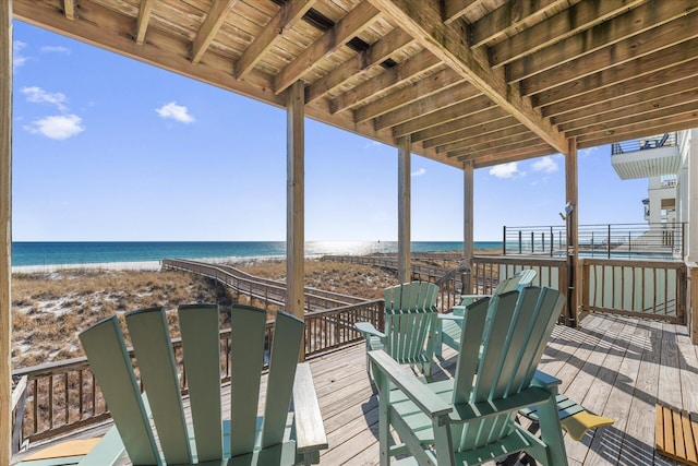 deck featuring a view of the beach and a water view