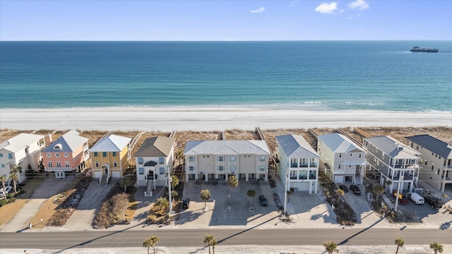 birds eye view of property with a water view and a beach view