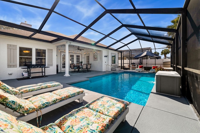 view of swimming pool with a lanai, a patio area, and ceiling fan