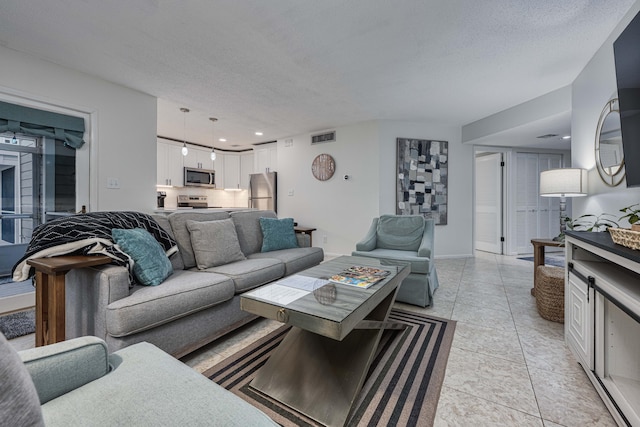 tiled living room featuring a textured ceiling