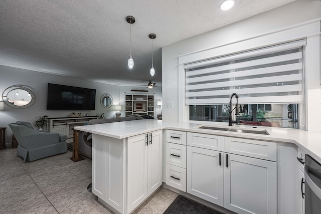 kitchen featuring kitchen peninsula, sink, pendant lighting, and white cabinets