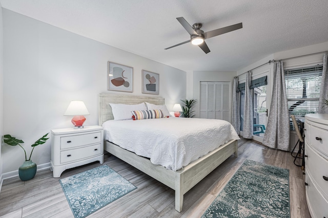 bedroom with a closet, ceiling fan, a textured ceiling, and wood-type flooring